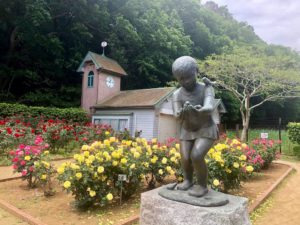 バラ園の時計台と子供の銅像とバラ