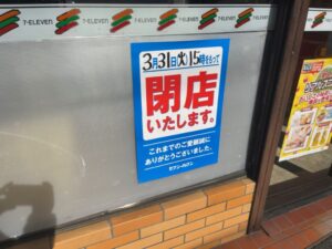 セブン-イレブン富浜店の窓に掲示された3月31日15時閉店のお知らせ(2026年3月15日筆者撮影)