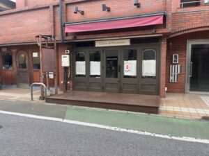 ロステリア・ディ・トシの店舗外観。市川市新田のレンガ調建物1階にある入口正面(2026年3月17日筆者撮影)
