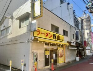 ラーメン豚山 本八幡店の角地側から見た店舗外観(2026年筆者撮影)