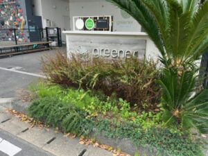 greenerのロゴ看板と入口前の植栽（2026年4月13日筆者撮影）