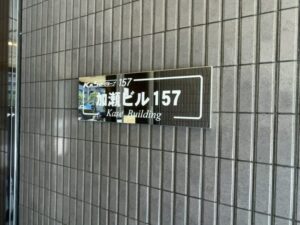 焼肉レストラン八功が入っていた建物のビル名看板(加瀬ビル157)(2026年4月16日筆者撮影)
