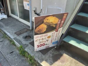 おかわりコロッケ 本八幡駅前店の店頭に置かれたコロッケの看板(2026年5月20日筆者撮影)