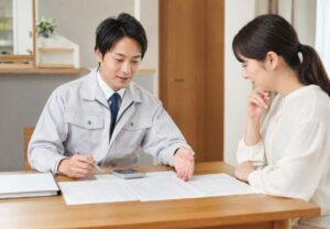 防水工事の見積書を見ながら担当者と住まいの相談をしている打ち合わせのイメージ
