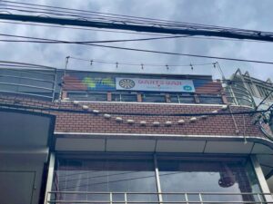 MAMABASE+ cafe&darts(ママベース)の外観看板、市川真間駅近くの建物4階に設置されたダーツバー看板(2026年6月4日筆者撮影)